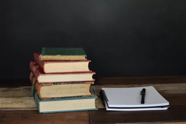 The picture shows a stack of books in a dark room.