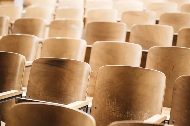 The image shows a bright hall with rows of chairs