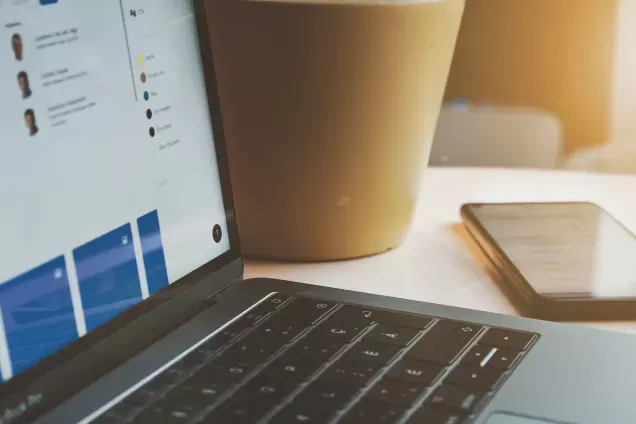 Computer keyboard and paper coffee cup. Photograph.