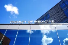 Sign on top of building, Faculty of Medicine, and blue sky. Photo.