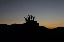 Silhouette of a group of people who have climbed a mountain. Photo.