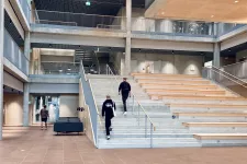 Persons climbing up large stairs. Photo.