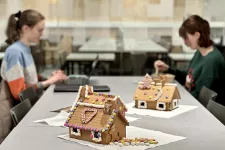 Ginger bread houses and students at a table. Photo.