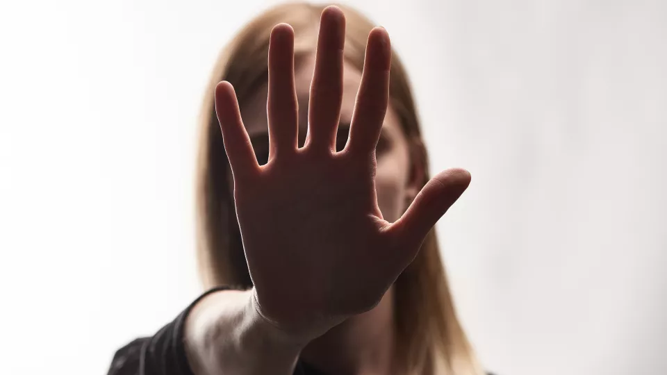 Foto av en kvinna som håller upp sin hand framför ansiktet