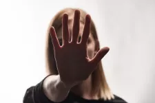 Foto av en kvinna som håller upp sin hand framför ansiktet
