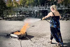 Kvinna släcker brand med skumslackare. Foto. Fotograf: Agata Garpenlind