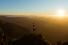 Yogi på en bergstopp i solnedgången. Foto.