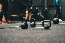 Kettlebells i förgrunden på ett gymgolv. Foto: Unsplash